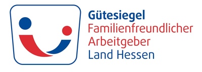 Logo mit stilisierter Darstellung von zwei stilisierten Personen in Rot und Blau, die einander zugewandt sind und gemeinsam ein lächelndes Gesicht formen. Rechts daneben steht der Text: „Gütesiegel Familienfreundlicher Arbeitgeber Land Hessen“. Das Logo signalisiert, dass der ausgezeichnete Arbeitgeber familienfreundliche Arbeitsbedingungen bietet.